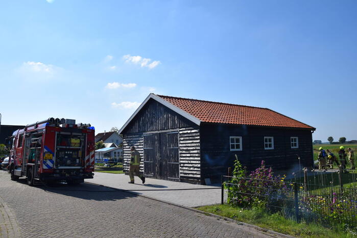 Houten balken achter schuur vlam gevat