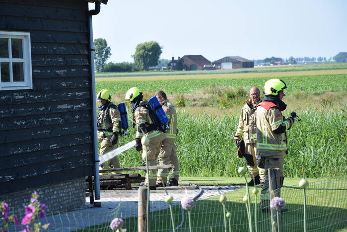 Houten balken achter schuur vlam gevat