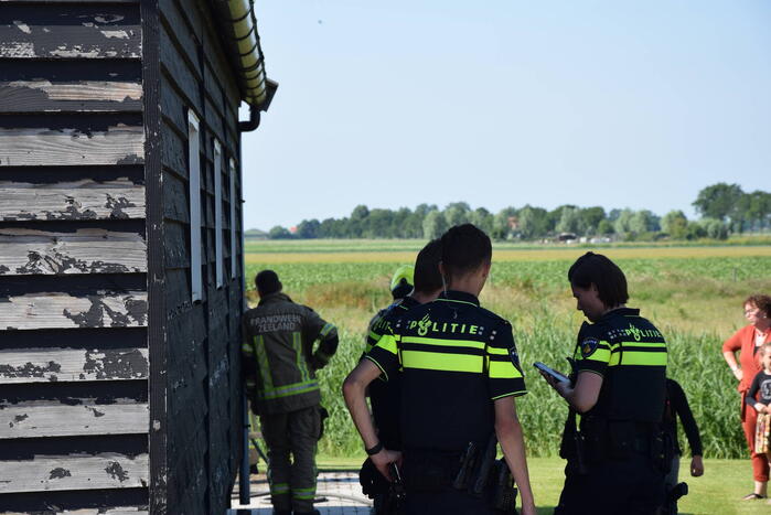 Houten balken achter schuur vlam gevat