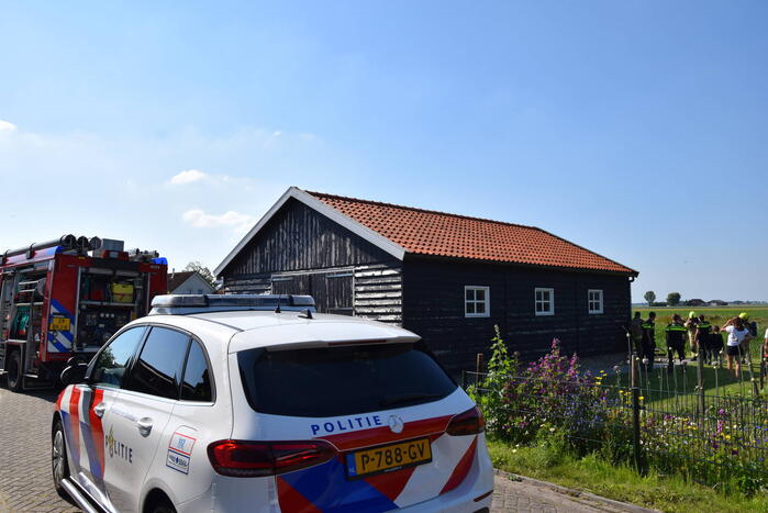 Houten balken achter schuur vlam gevat