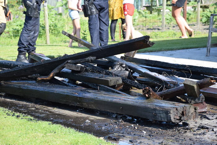 Houten balken achter schuur vlam gevat