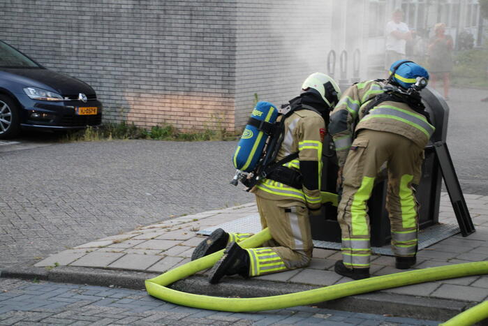 Brandweer blust brandende container