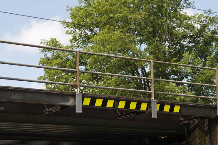 Vrachtwagen rijdt bord af van spoorbrug