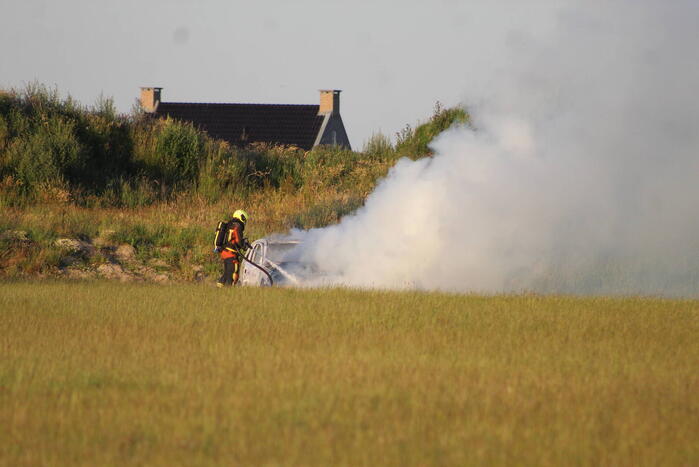 Auto midden in het veld verwoest vanwege brand