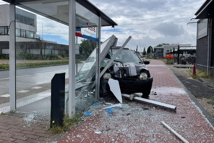 Auto crasht dwars door bushokje heen