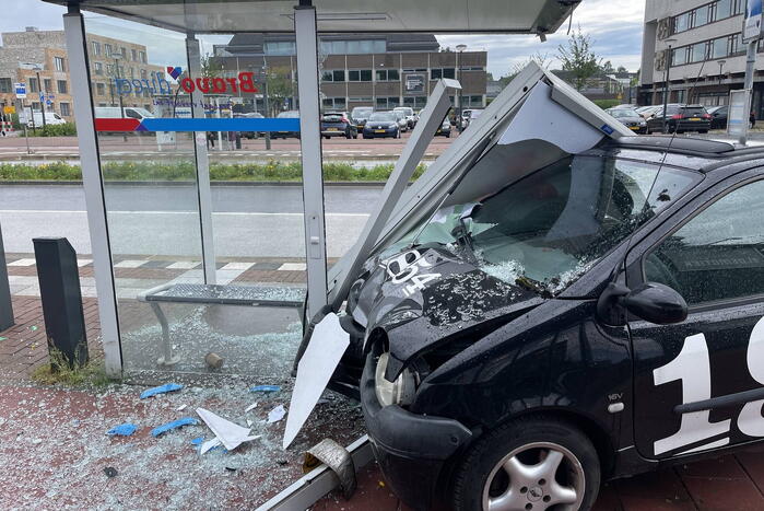 Auto crasht dwars door bushokje heen