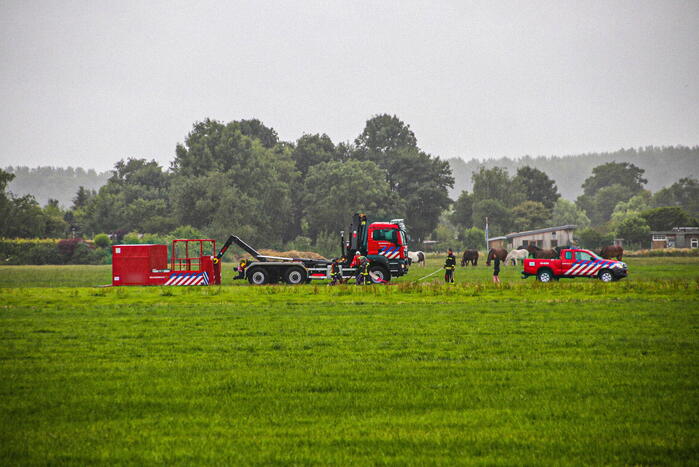 Paard met kraan uit sloot getakeld