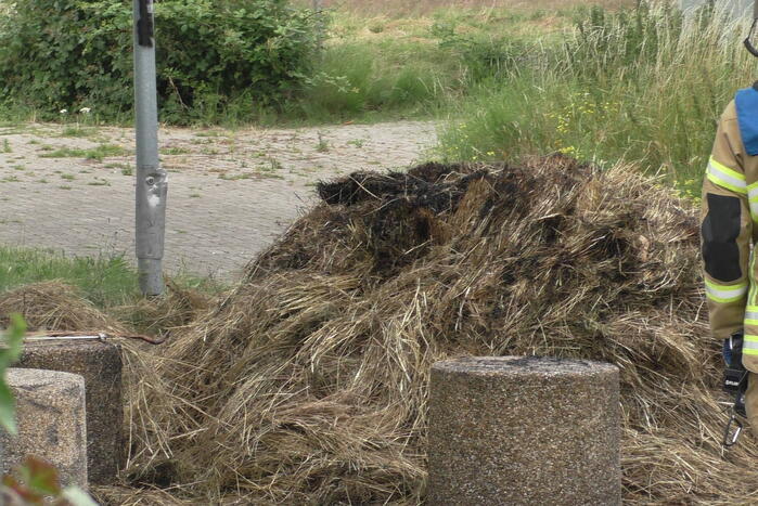 Brandweer blust brandende hooibaal