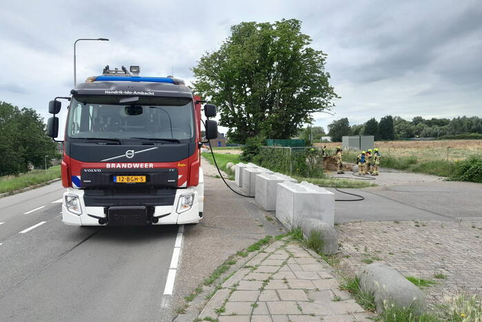 Brandweer blust brandende hooibaal