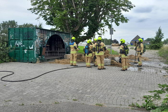 Brandweer blust brandende hooibaal