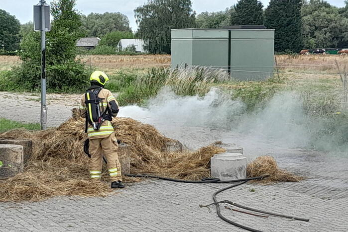 Brandweer blust brandende hooibaal