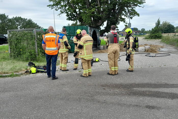 Brandweer blust brandende hooibaal