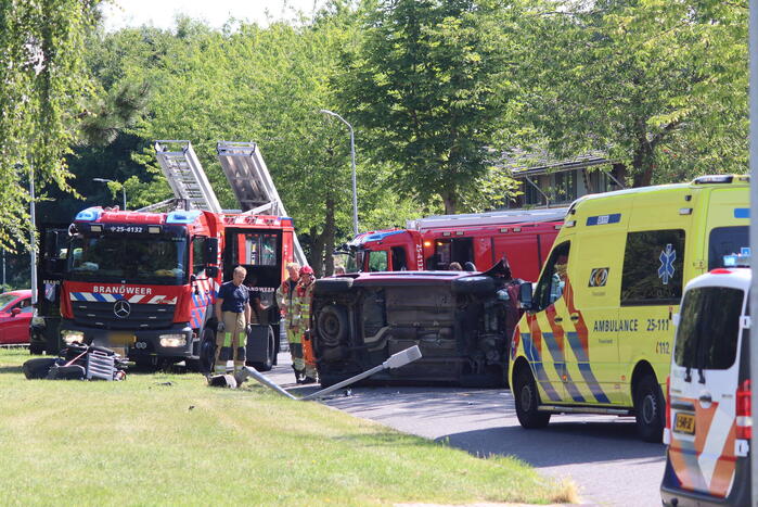 Auto op de kant na botsing met lantaarnpaal