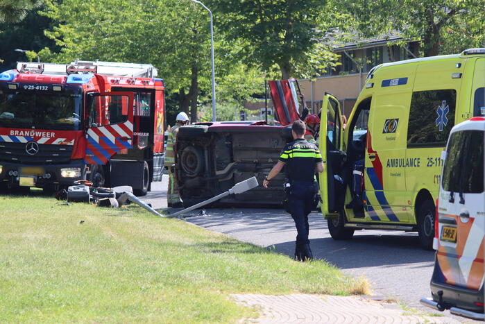 Auto op de kant na botsing met lantaarnpaal