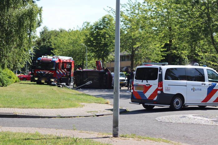 Auto op de kant na botsing met lantaarnpaal