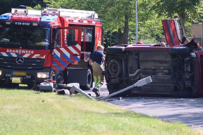 Auto op de kant na botsing met lantaarnpaal