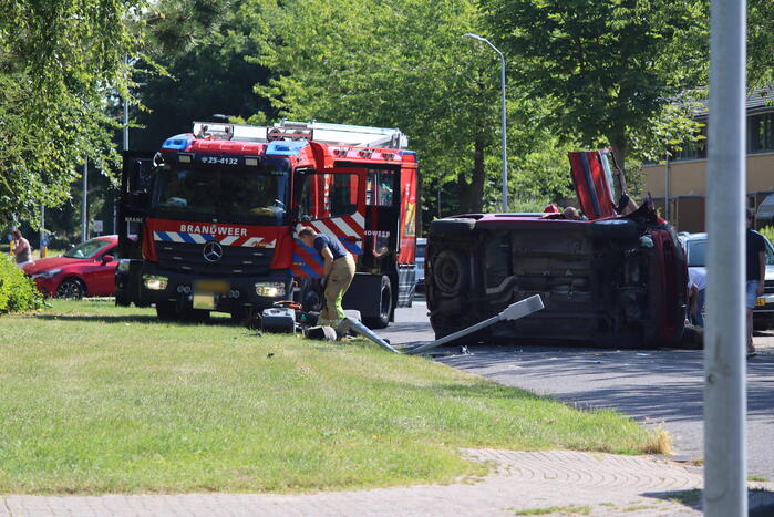 Auto op de kant na botsing met lantaarnpaal