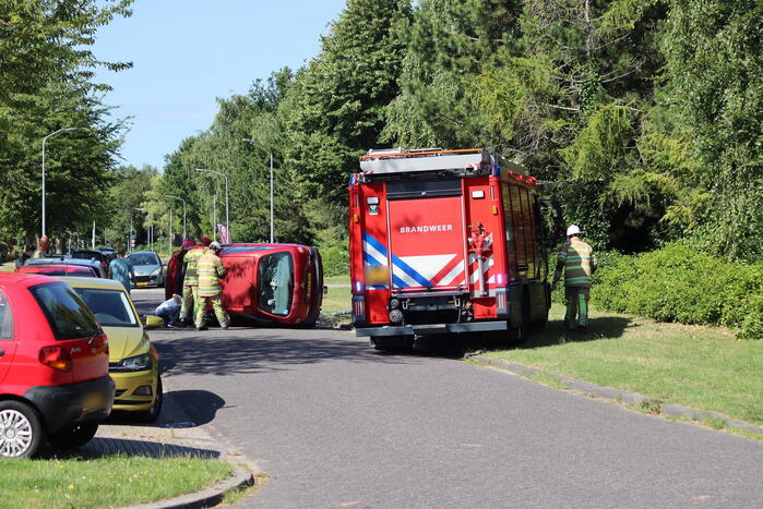 Auto op de kant na botsing met lantaarnpaal