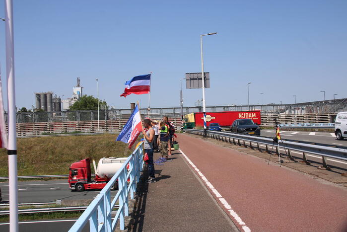 Actievoerders zwaaien met omgekeerde vlaggen naar verkeer op A15