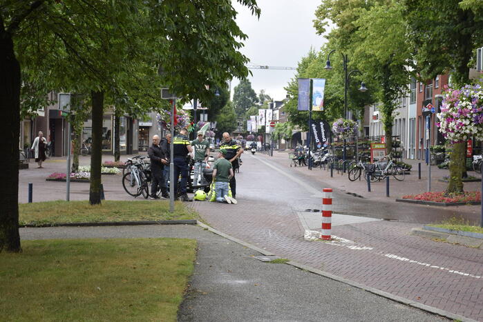 Persoon met bezorgscooter ten val