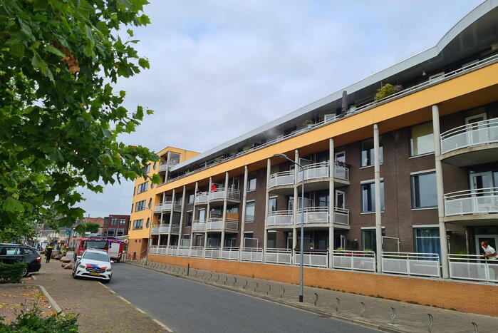 Zwarte rook uit appartement vanwege brand