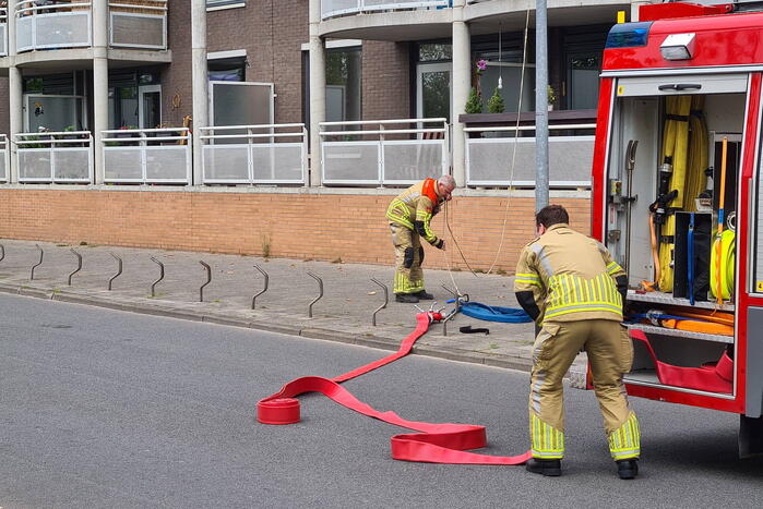 Zwarte rook uit appartement vanwege brand