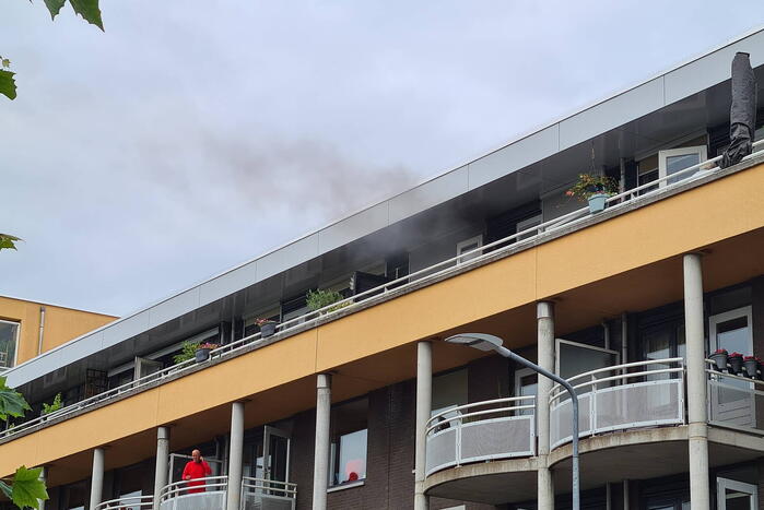 Zwarte rook uit appartement vanwege brand
