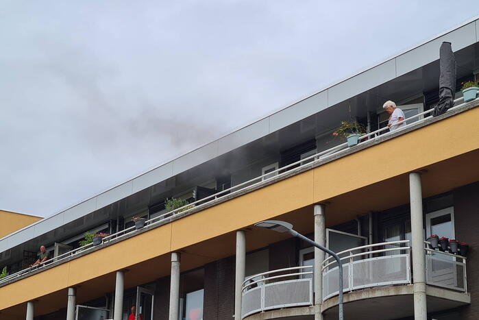Zwarte rook uit appartement vanwege brand