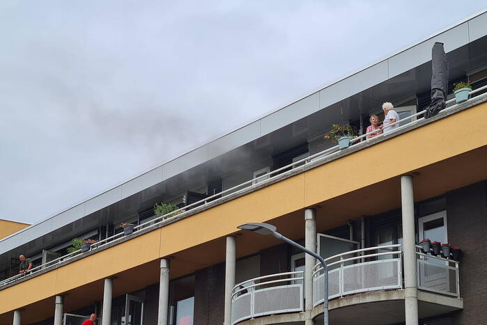 Zwarte rook uit appartement vanwege brand