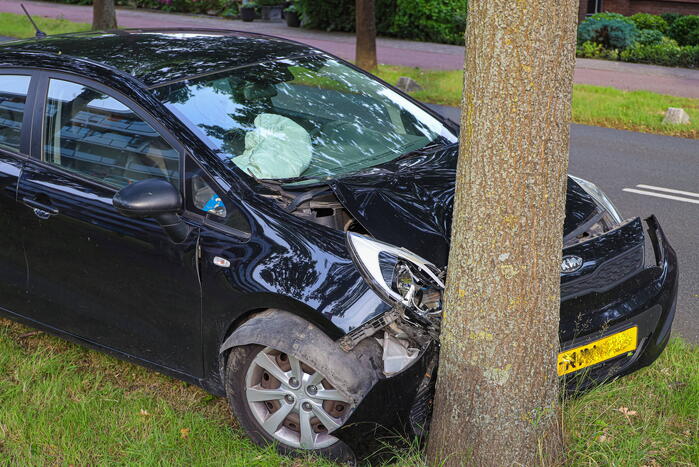 Auto botst tegen boom inzittende naar ziekenhuis