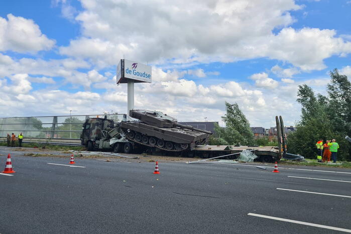 Vrachtwagen met gevechtstank boort zich in geluidswal