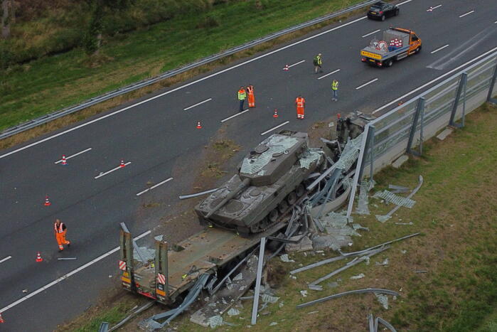 Vrachtwagen met gevechtstank boort zich in geluidswal
