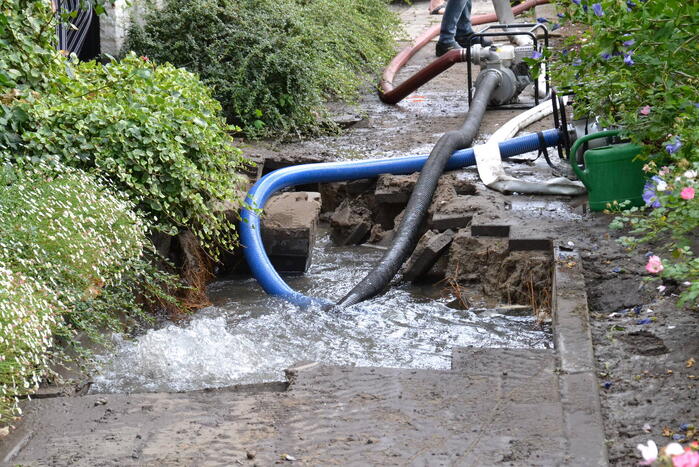 Groot gat ontstaan in voetpad vanwege waterlekkage