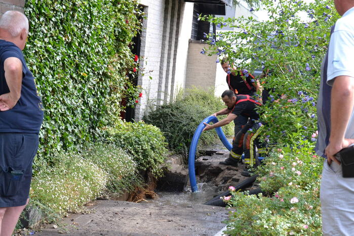 Groot gat ontstaan in voetpad vanwege waterlekkage