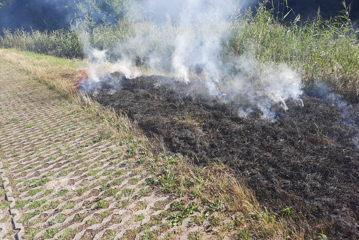 Omstanders doven bermbrand met kleed