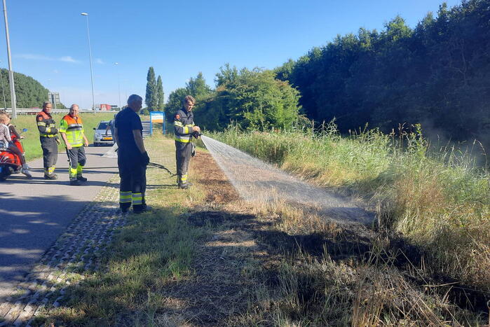 Omstanders doven bermbrand met kleed