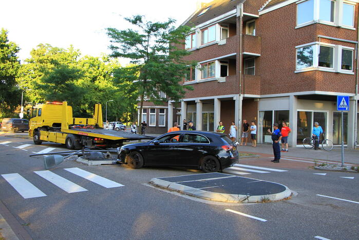 Personenauto uit de bocht, lantaarnpaal geraakt