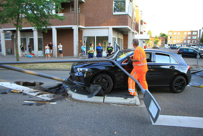 Personenauto uit de bocht, lantaarnpaal geraakt