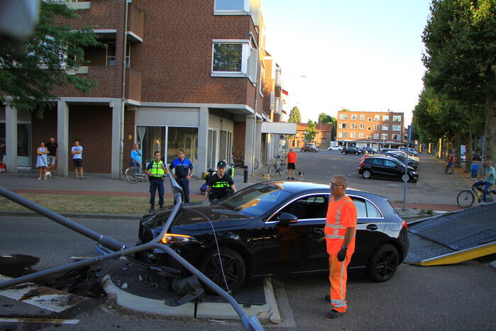 Personenauto uit de bocht, lantaarnpaal geraakt