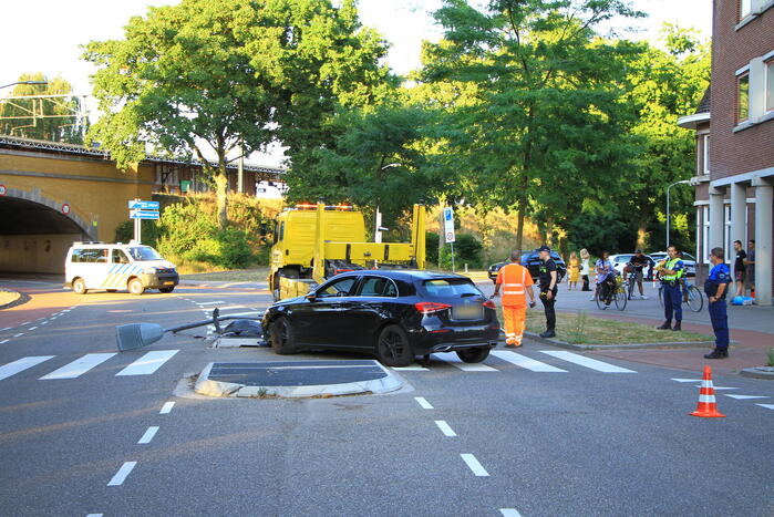 Personenauto uit de bocht, lantaarnpaal geraakt
