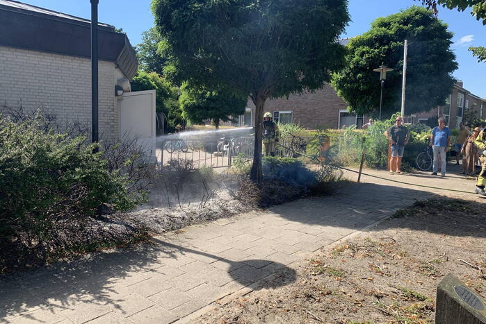 Brandende struiken naast gebouw snel geblust