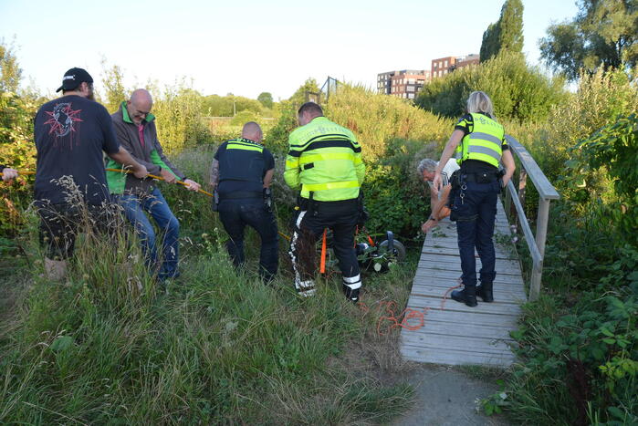 Man op scootmobiel rijdt vanaf brug het water in