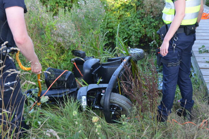 Man op scootmobiel rijdt vanaf brug het water in