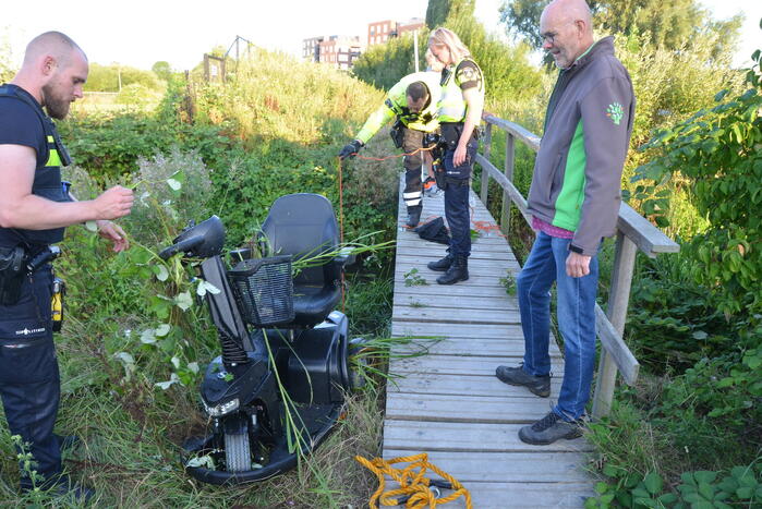 Man op scootmobiel rijdt vanaf brug het water in