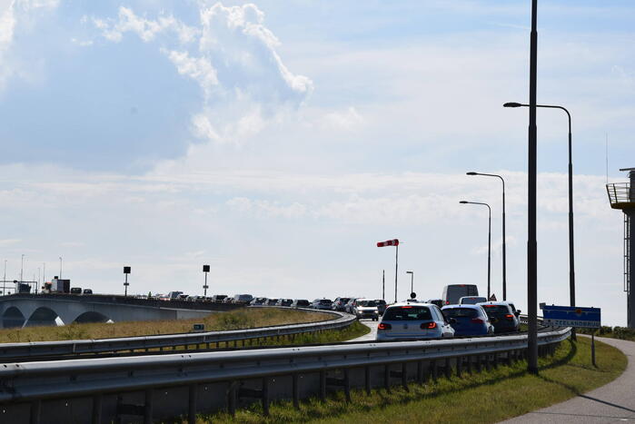 Vrachtwagen schampt wand Zeelandbrug na klapband