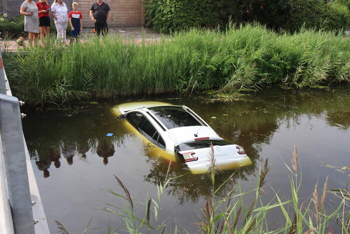 Auto raakt te water naast brug