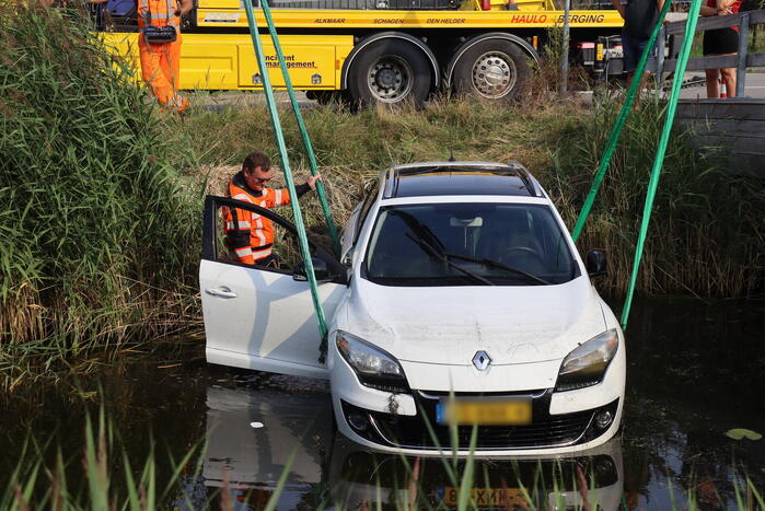 Auto raakt te water naast brug