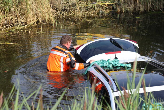 Auto raakt te water naast brug