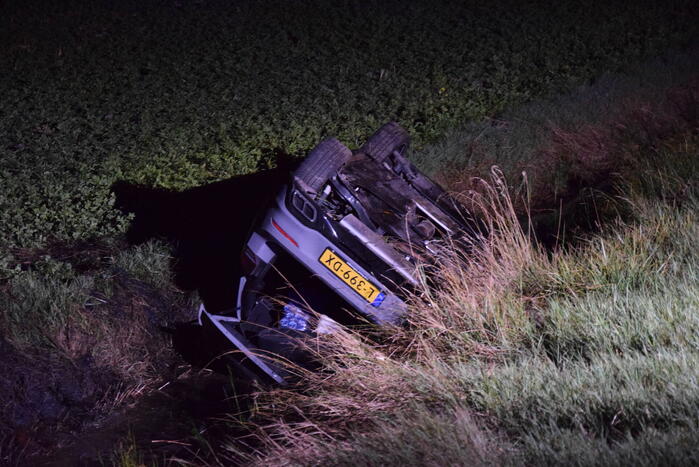 Auto op zijn kop in sloot naast talud