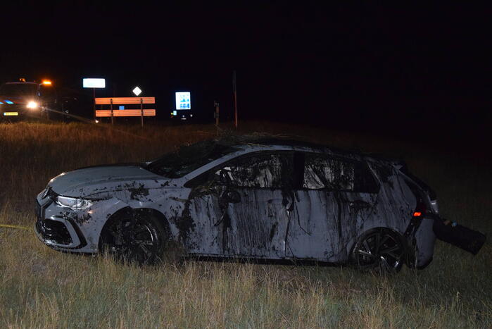 Auto op zijn kop in sloot naast talud